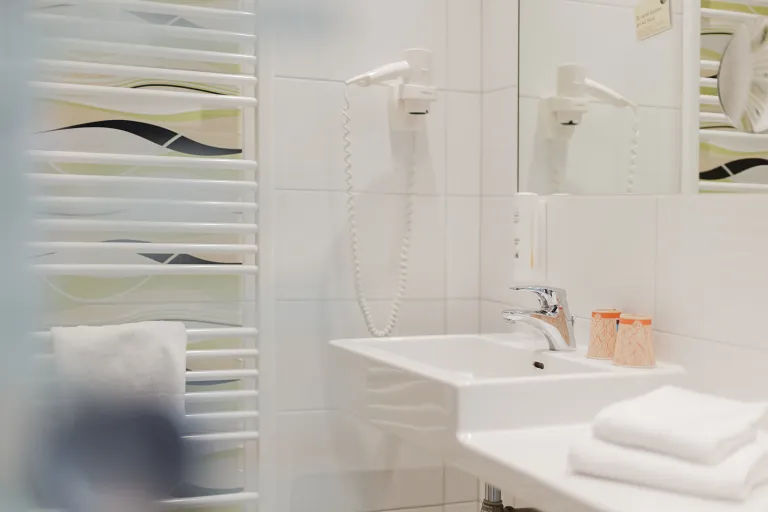 Badezimmer mit Föhn und Handtuchheizkörper im Motel Baden