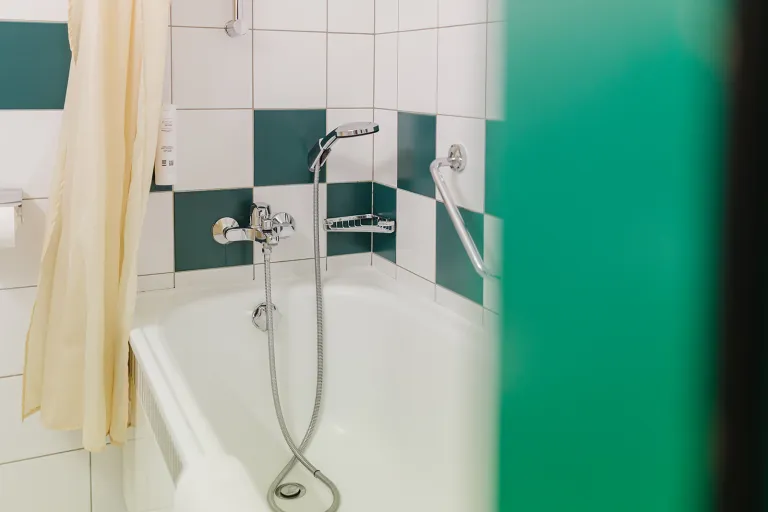 Badewanne mit Handbrause im Motel Baden