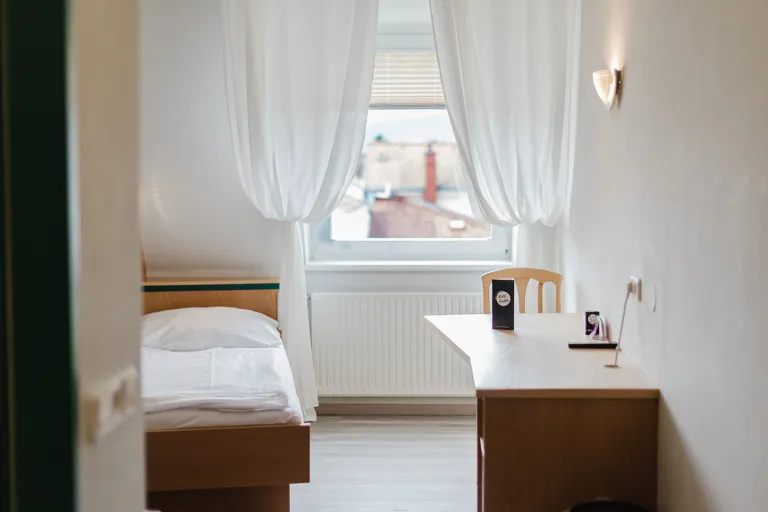 Doppelzimmer im Dachgeschoss mit Bett und Schreibtisch im Motel Baden