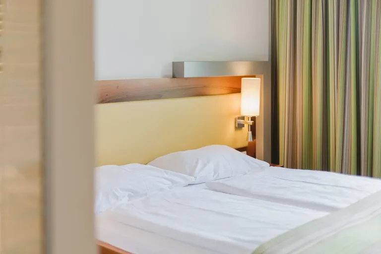 Doppelbett mit Vorhang im Motel Baden
