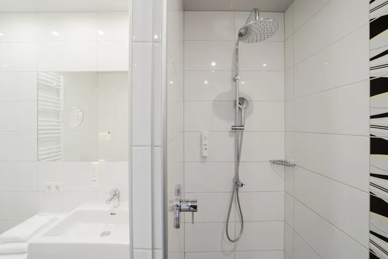 Dusche mit Dekorfliesen im Badezimmer des Motel Baden