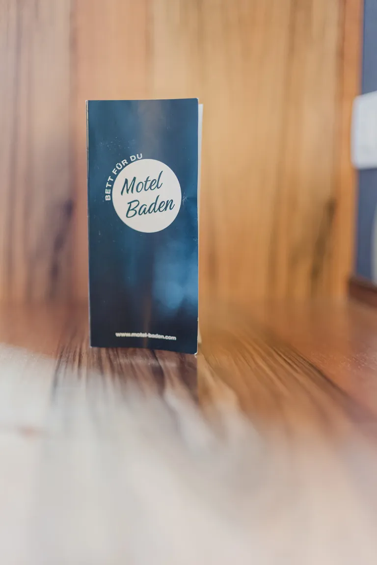 Motel-Baden-Flyer vor Holzwand