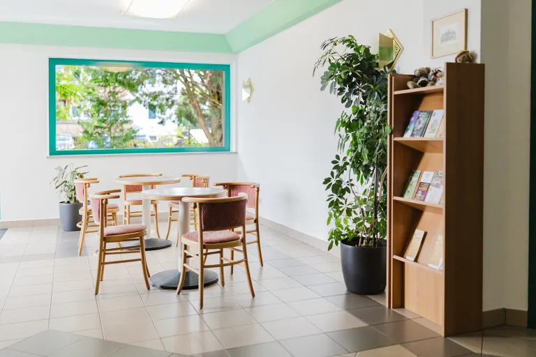 Eingangsbereich mit Fenster und Bücherregal im Motel Baden