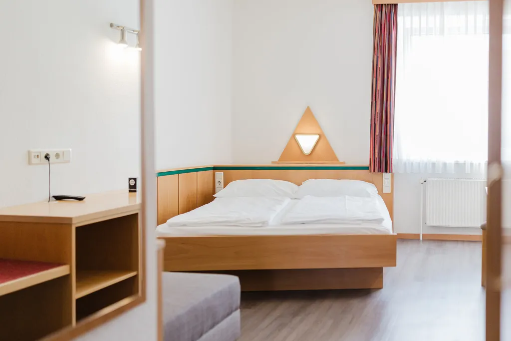 Doppelbett mit dreieckiger Leuchte Doppelbett mit dreieckiger Leuchte im Motel Baden