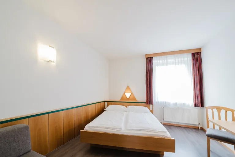 Doppelbett am Fenster im Doppelzimmer mit privater Garage im Motel Baden