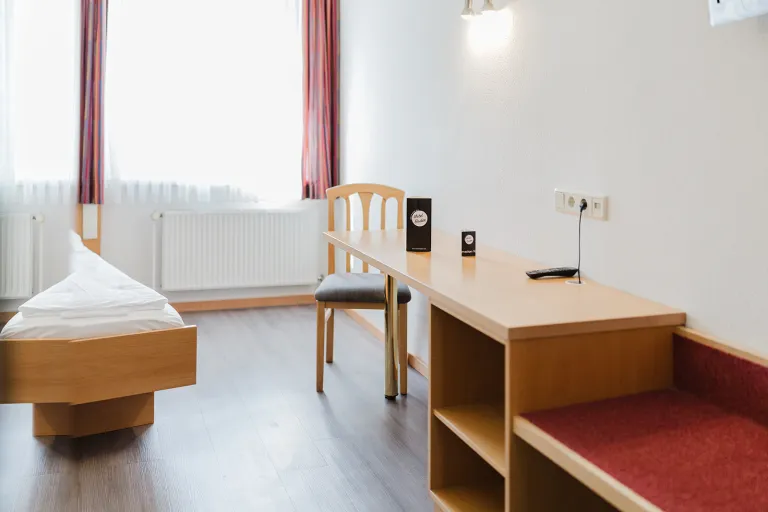 Sitzbank am Fenster und Schreibtisch im Doppelzimmer mit privater Garage im Motel Baden