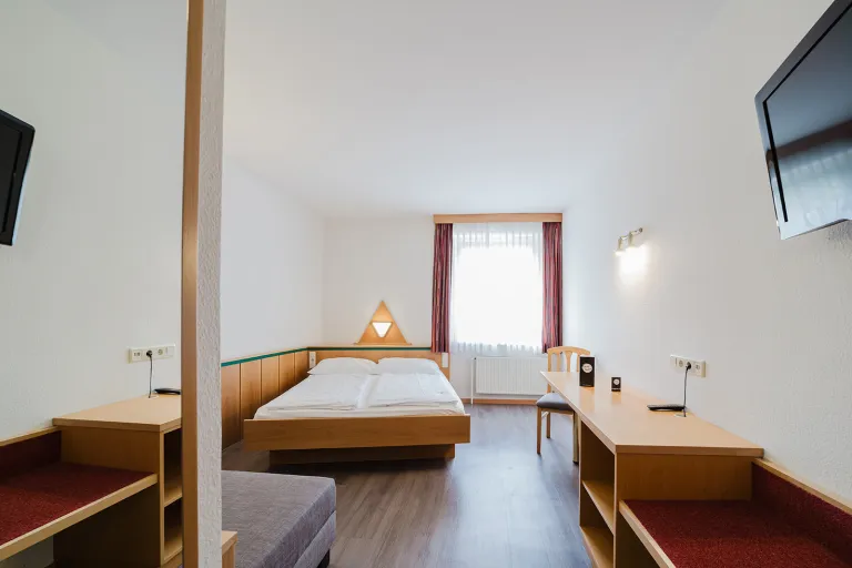 Doppelzimmer mit privater Garage: Doppelbett, Flat-TV und Schreibtisch im Motel Baden