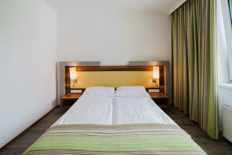 Doppelbett mit Leseleuchten im Motel Baden