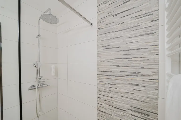 Regendusche mit Fliesen in Steinoptik im Motel Baden