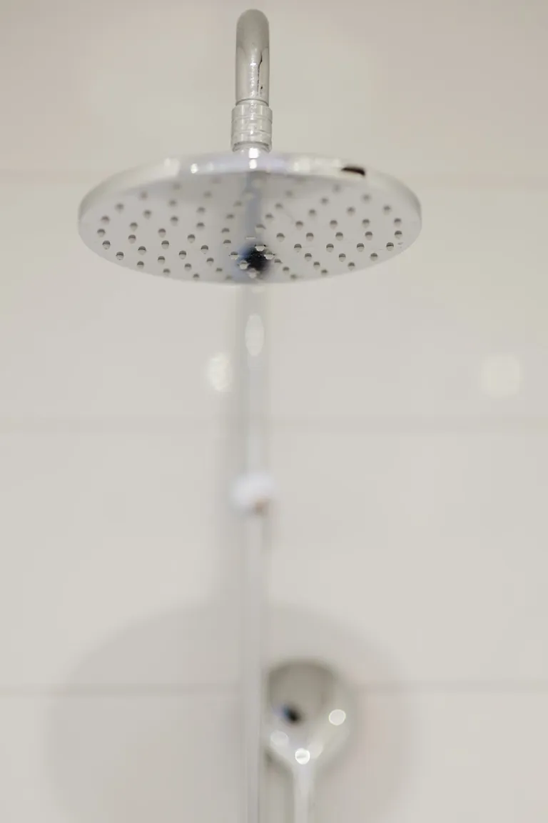 Runder Regenduschkopf im Badezimmer des Motel Baden
