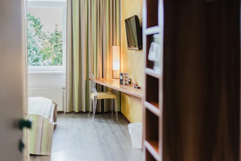 Doppelzimmer mit Schreibtisch, Fenster und Regal im Motel Baden