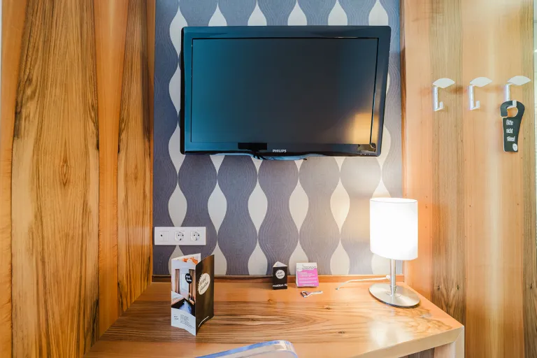 Schreibtisch mit Lampe und Flat-TV im Motel Baden