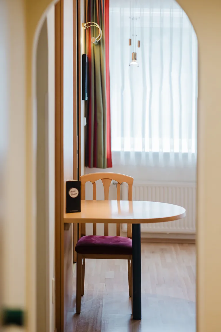 Sitzplatz mit Tisch und Stuhl am Fenster im Motel Baden