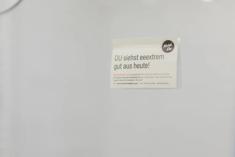 Karte „DU siehst einfach gut aus heute!“ an der Wand im Motel Baden