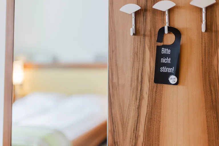 Türhänger an der Garderobe, Bett im Hintergrund im Motel Baden