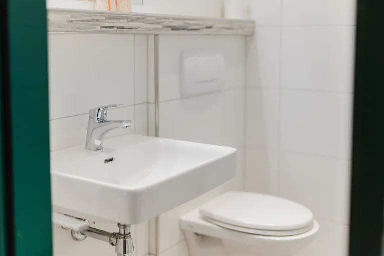 Waschbecken und WC im Badezimmer des Motel Baden